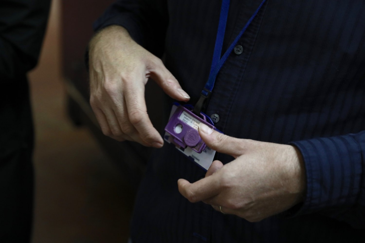 Close-up of a visitorās lanyard card being slipped into a custom Arduino-powered āmission consoleā reader, which triggers the next branch of the installationās narrative and records the teamās collective choice.